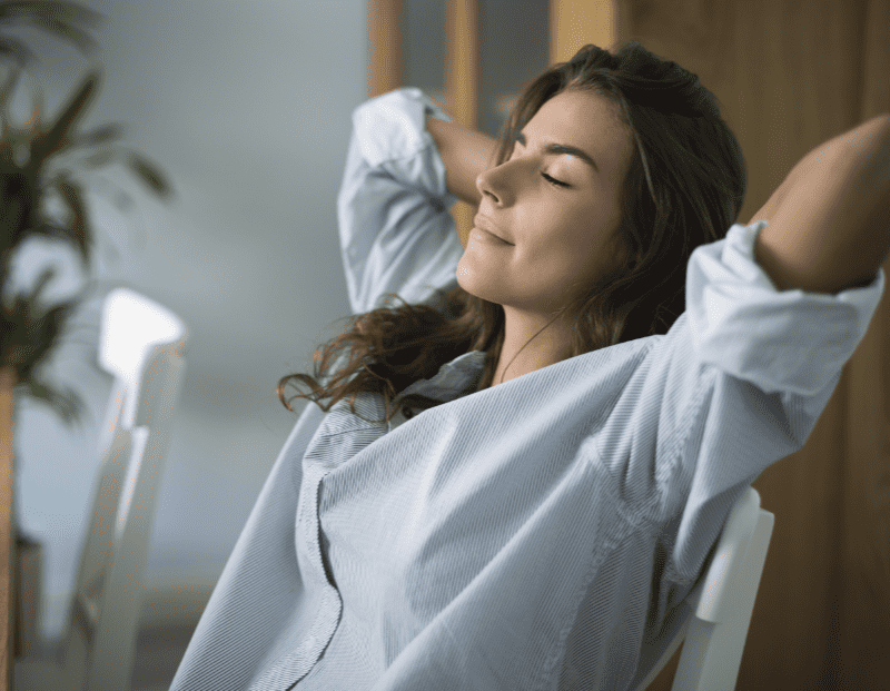 Entspanntes, stressfreies Business – eine Frau, die sich in ihrem Bürostuhl zurücklehnt